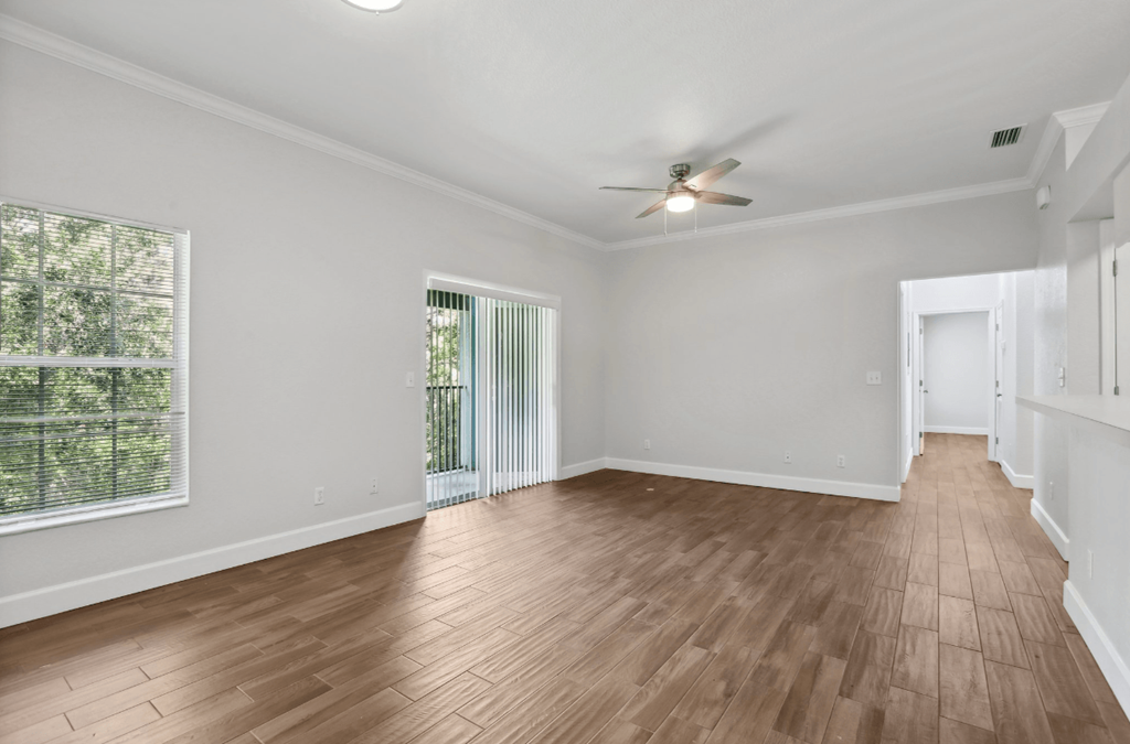 A room with wooden flooring and a ceiling fan.